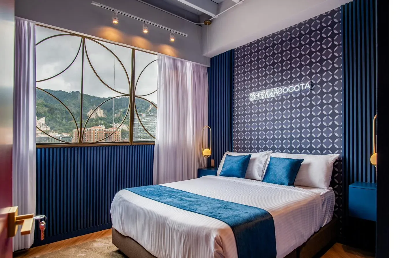 Suite principal · cabecero azul y vista a los cerros